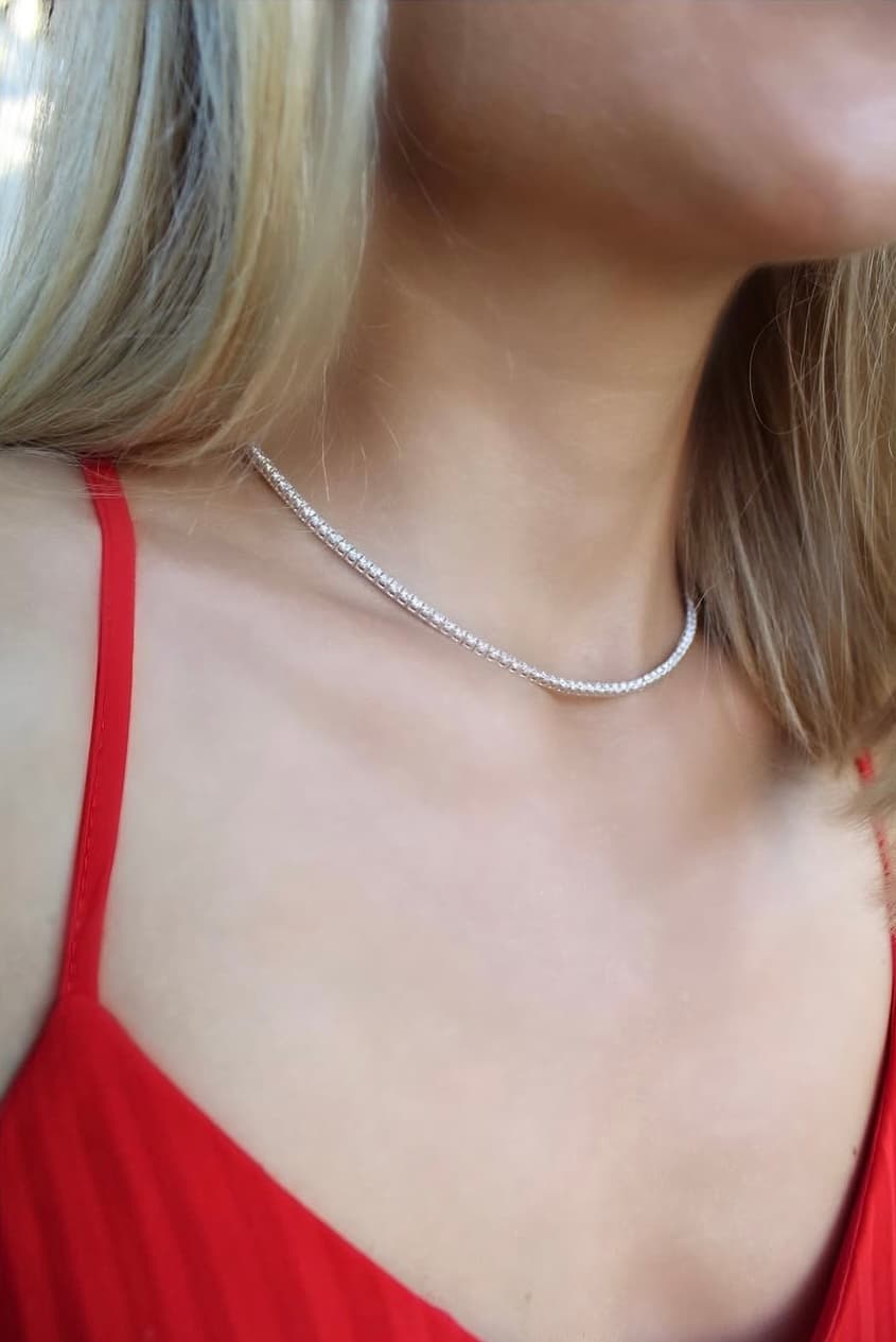 Gold 'Rise' necklace on polka dot cream sweater